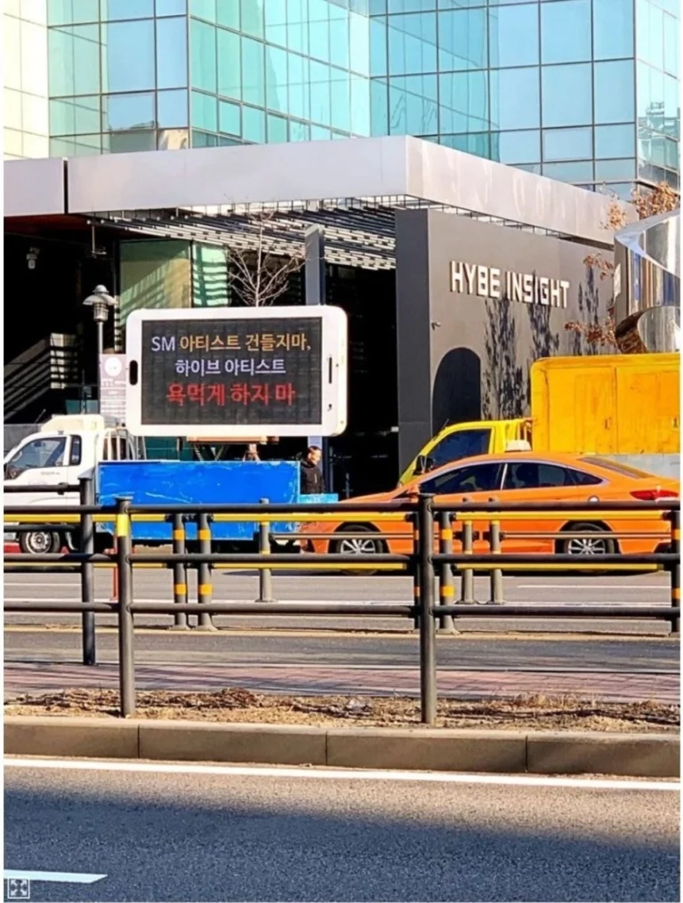 "Don't you dare mess with SM artists. Don't make us curse at HYBE artists" SM fans send protest truck in front of HYBE