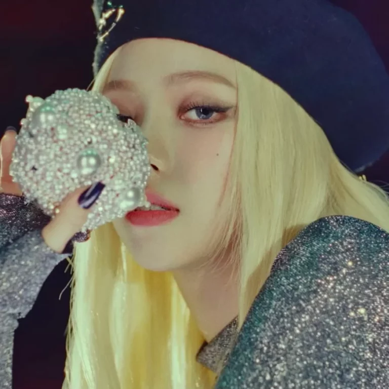 Karina wearing a beret with blonde hair in Aespa's song video